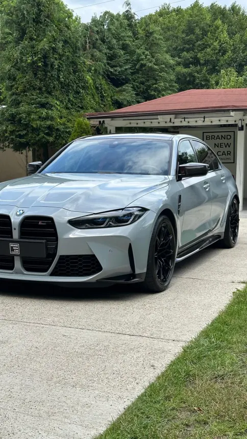 Jasnoszare BMW M3 z czarnymi felgami przed studiem