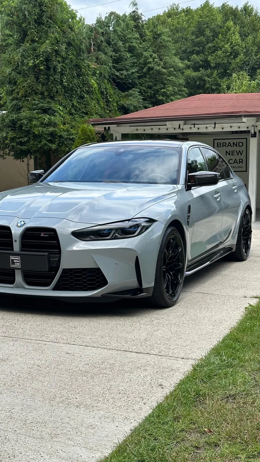 Jasnoszare BMW M3 z czarnymi felgami przed studiem Brand New Car