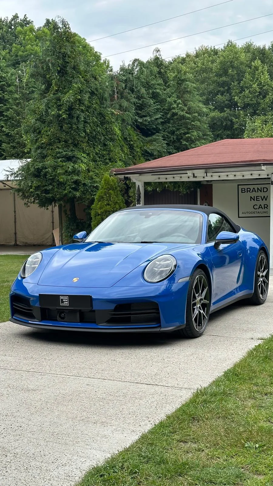 Niebieskie Porsche 911 Cabriolet przed studiem Brand New Car