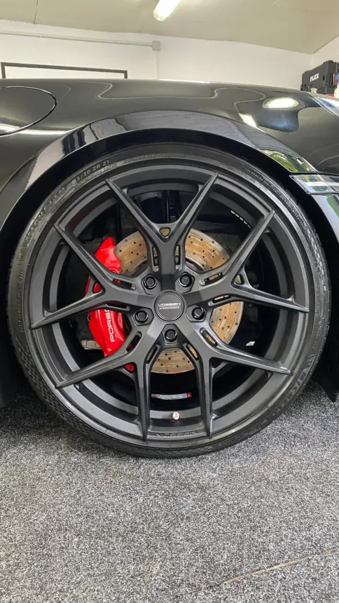 Ciemna felga Porsche i czerwony zacisk hamulcowy